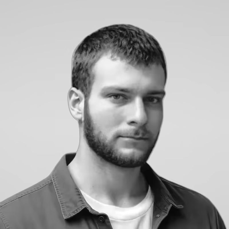 Black and white portrait of Anatolii Litvinov on a light gray studio background.