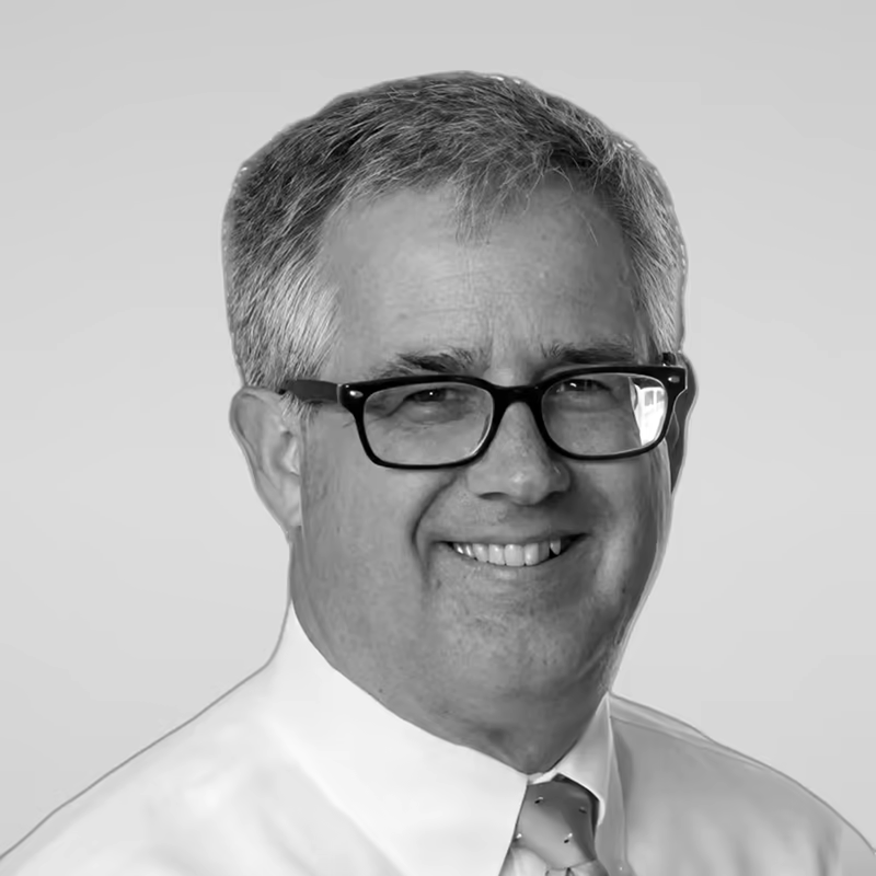 Black and white portrait of David Farrow on a light gray studio background.