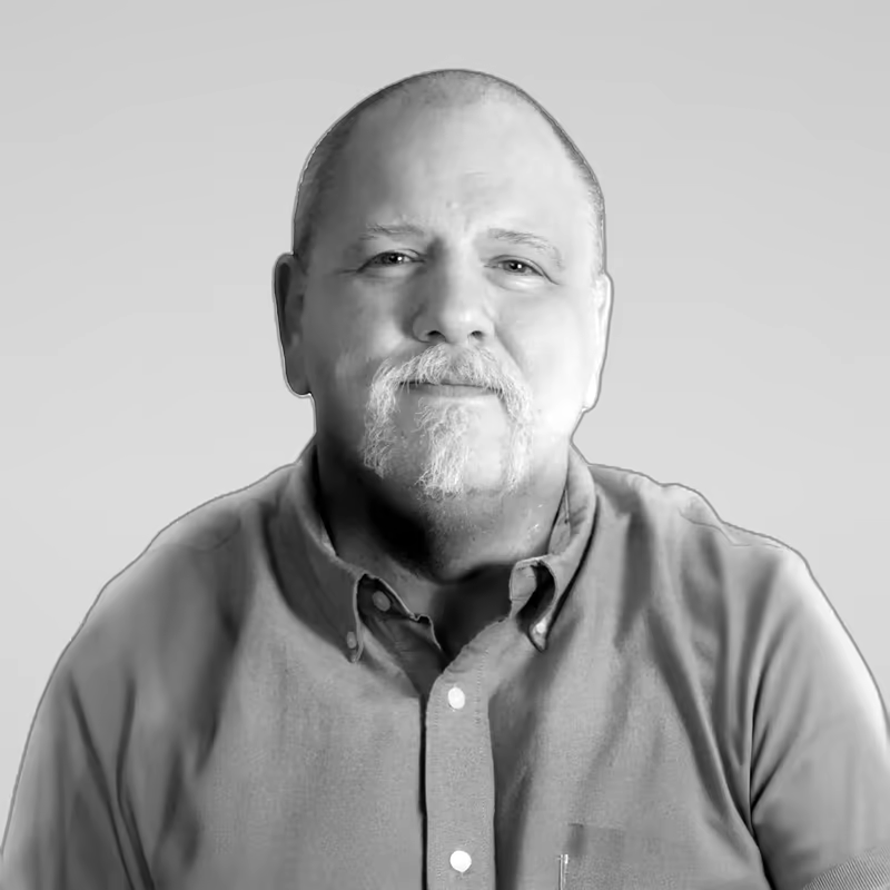 Black and white portrait of Jason Mogavero on a light gray studio background.