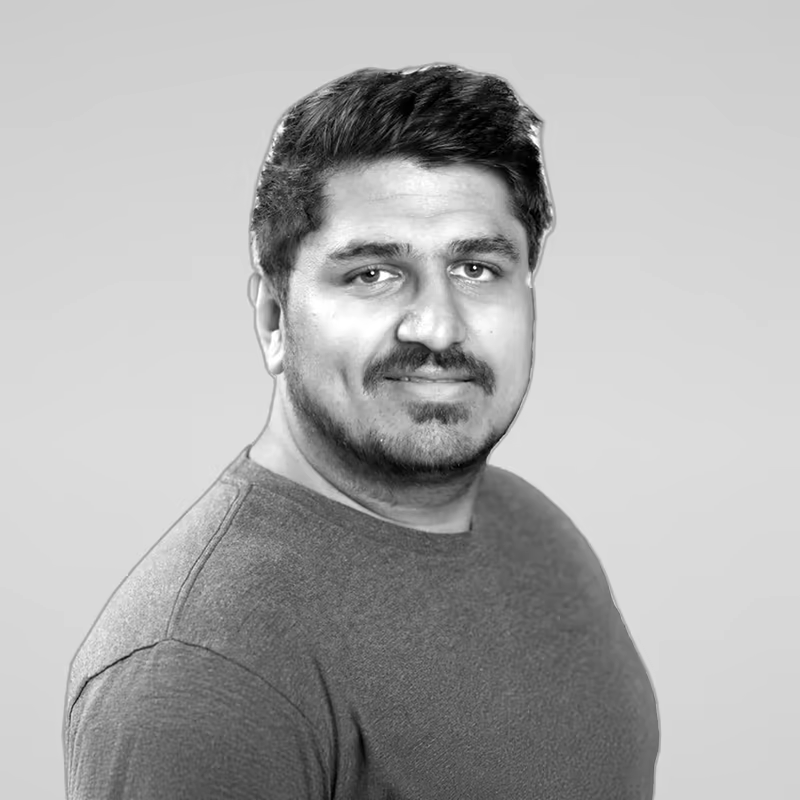 Black and white portrait of Kashish Mittal on a light gray studio background.