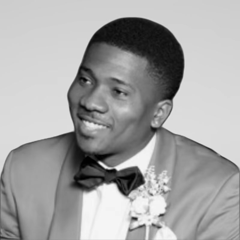 Black and white portrait of Keon Prewitt on a light gray studio background.