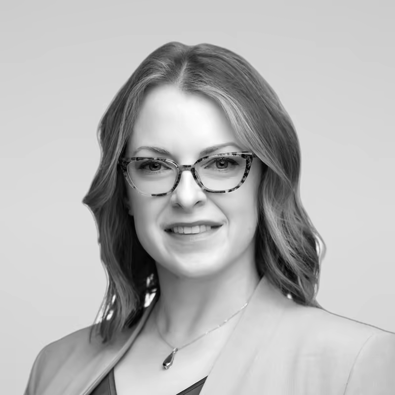 Black and white portrait of Lora Vaughn on a light gray studio background.