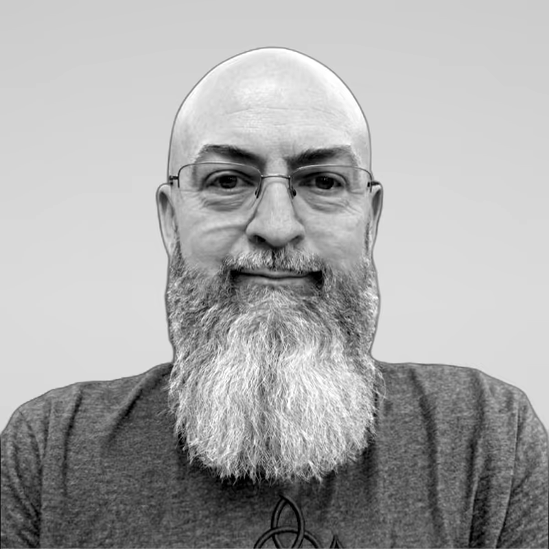 Black and white portrait of Mike Geehan on a light gray studio background.