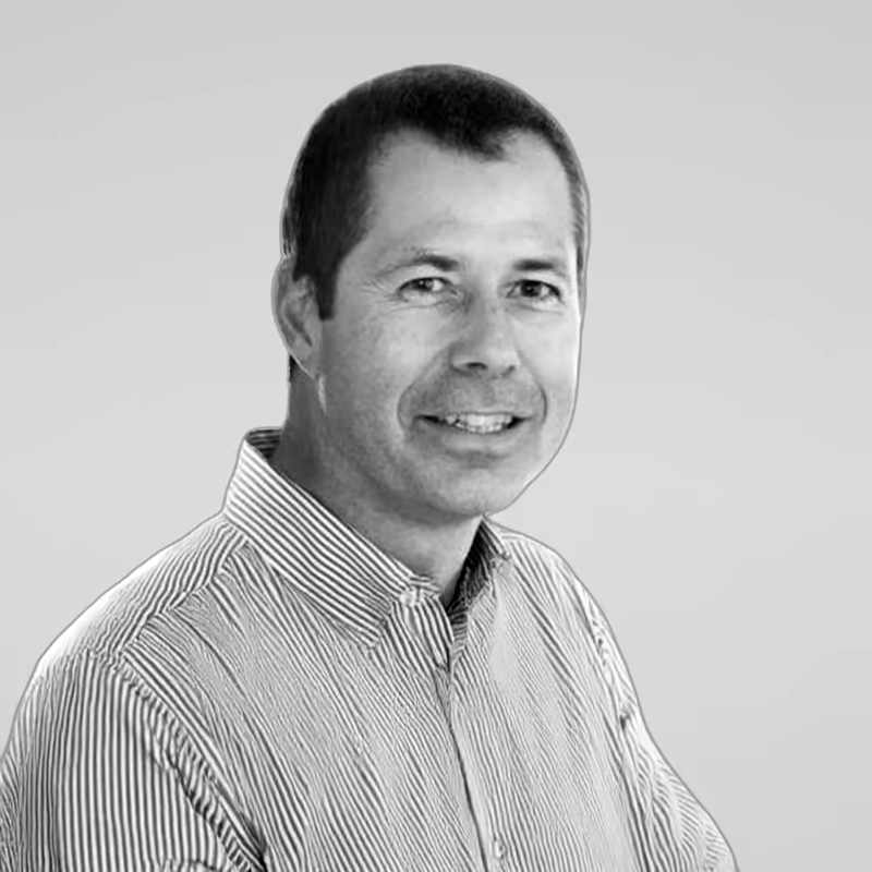 Black and white portrait of Paddy Roberts on a light gray studio background.