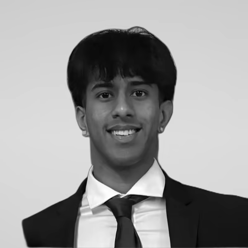 Black and white portrait of Pranav Chandrasekhar on a light gray studio background.