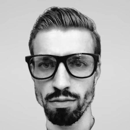 Black and white portrait of Rokas Zickevicius on a light gray studio background.