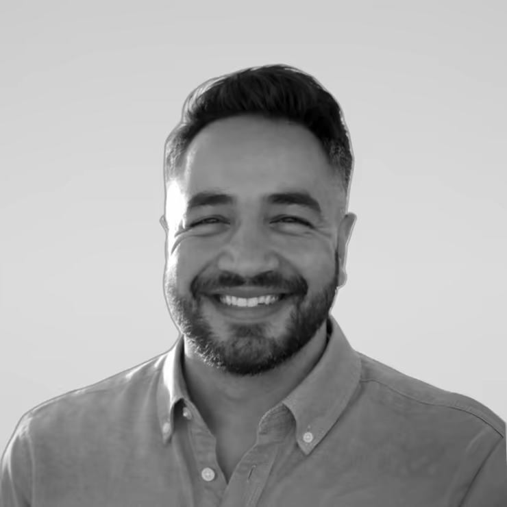 Black and white portrait of Volkan Kutal on a light gray studio background.
